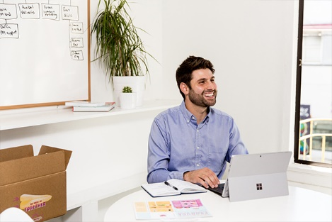 Imperfect Produce’s CEO sitting at a desk working on a Surface device.